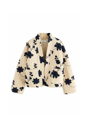 Beige gewatteerde jas met marineblauwe bloemenprint, open voorkant, twee voorzakken en een relaxte pasvorm. Zachte textuur en opvallende stikseldetails.
