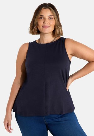 Top senza maniche di colore navy realizzato in tessuto morbido, con scollo rotondo e dettagli sottili, abbinato a jeans blu scuro.