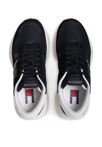 Μαύρα αθλητικά παπούτσια με πλέγμα στην επάνω επιφάνεια και σουέντ λεπτομέρειες. Λευκή μεσαία σόλα, μαύρα κορδόνια και ετικέτα με λογότυπο στη γλώσσα. Εξωτερική σόλα από καουτσούκ για πρόσφυση.