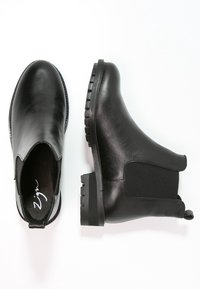 Czarne skórzane botki Chelsea o gładkim wykończeniu, z elastycznymi bocznymi panelami i teksturowanymi gumowymi podeszwami dla lepszej przyczepności. Posiadają pętelkę ułatwiającą zakładanie.