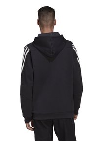Felpa nera con cappuccio e strisce bianche sulle spalle, realizzata in tessuto morbido. Presenta una vestibilità rilassata e polsini a costine per il massimo comfort.