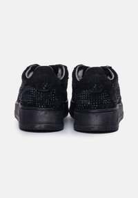 Sneakers neri con materiale testurizzato, dotati di accenti in strass sulla parte superiore, suole piatte e colli imbottiti per il comfort.
