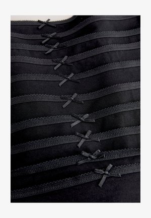 Czarna bielizna z delikatną koronkową lamówką i satynowymi kokardkami, ułożona w poziome warstwy, prezentująca gładką tkaninę i jednolitą teksturę.