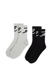 Dos pares de calcetines acanalados: uno gris con texto negro y otro negro con texto gris. Ambos tienen una altura de caña media y una textura suave.