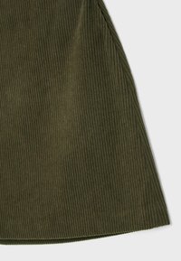 Tissu en velours côtelé vert olive, présentant une texture à côtes verticales. L'ourlet est légèrement courbé, ce qui améliore la silhouette générale du vêtement.