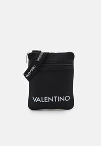 Pochette noire en nylon avec une fermeture éclair, ornée d'une sangle logo et d'un texte 'VALENTINO' blanc contrastant sur le devant. Texture lisse.