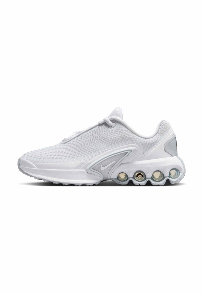 Zapatilla deportiva blanca con parte superior de malla, diseño curvado, detalles en gris y una suela acolchada distintiva que presenta burbujas de aire visibles.