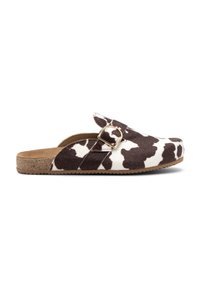 Zapato tipo slip-on con estampado de vaca, presentando una parte superior texturizada, detalle de hebilla dorada y una planta de corcho sobre una suela flexible de goma.