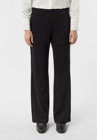 Czarne spodnie o szerokich nogawkach wykonane z gładkiej tkaniny, z wysokim stanem i subtelnymi bocznymi szwami dla dopasowanego wyglądu.