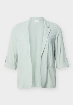 Ανοιχτό πράσινο σακάκι με ανοιχτό μπροστινό μέρος, μανίκια γυρισμένα και δύο μπροστινές τσέπες, παρουσιάζεται σε απλό ανοιχτό φόντο.