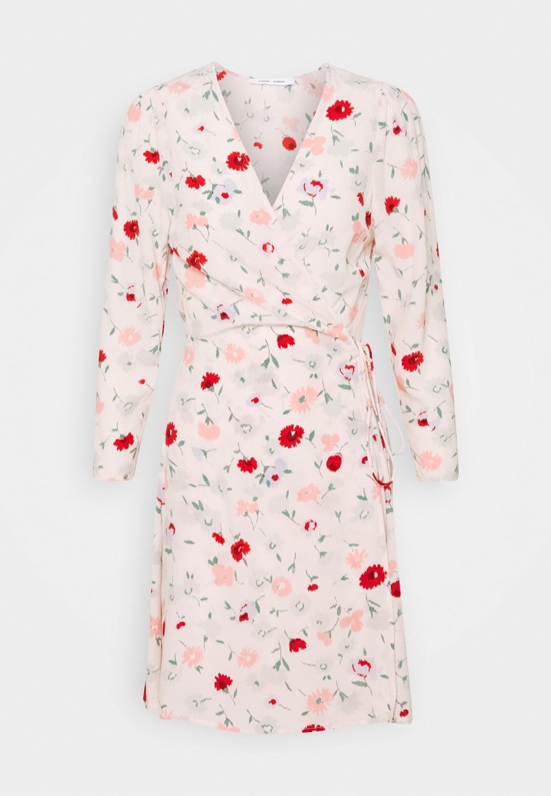 Robe portefeuille rose clair avec manches longues, motif floral rouge et rose pâle, encolure en V et détail noué sur le côté.