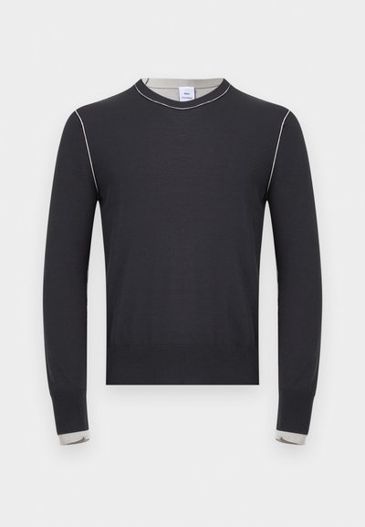 Pull noir à manches longues avec des surpiqûres blanches le long des épaules et des poignets, avec un col rond et un ourlet et des poignets côtelés.