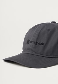 Casquette grise en tissu doux, dotée d'un bord courbé et d'un logo "snow peak" brodé en noir sur le devant. Design simple sans motifs supplémentaires.