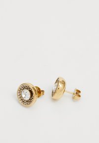 Boucles d'oreilles en métal doré avec un cristal central transparent entouré de pierres plus petites, design circulaire, avec une fermeture à poussoir et un détail de logo.