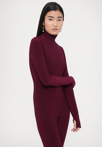 Bordové priliehavé body s dlhými rukávmi a vysokým golierom. Hladká textúra, minimálne švy a otvor na palec na zápästí.