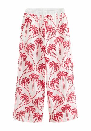 Pantalon blanc à jambes larges avec taille élastique, présentant un motif répétitif de palmiers rouges et de volutes en pointillés.