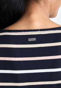 Pull marine à rayures avec des rayures horizontales blanches, roses et crème. Présente une étiquette en métal portant l'inscription "Barbour" au niveau de l'encolure arrière.