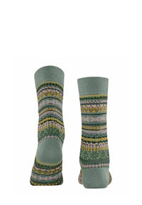Wielokolorowe skarpetki w odcieniach zieleni z złożonymi wzorami pasków i kształtów, z akcentami w różowym, żółtym i szarym.