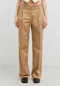Beige, geplooide broek met een rechte pijp ontwerp, gemaakt van glad, lichtgewicht stof. Heeft riemlussen en een schone, op maat gemaakte uitstraling.