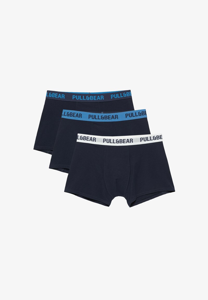 Trois paires de boxers pour hommes bleu foncé avec des ceintures élastiques dans différentes nuances de bleu et de blanc, toutes de la marque "PULL&BEAR."