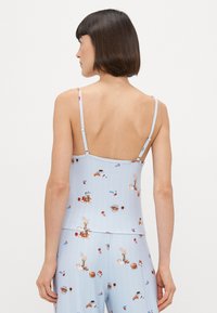 Jasnoniebieski top na ramiączkach z teksturą ryżową i barwnym wzorem ciast oraz akcesoriów do kawy, regulowane ramiączka spaghetti.