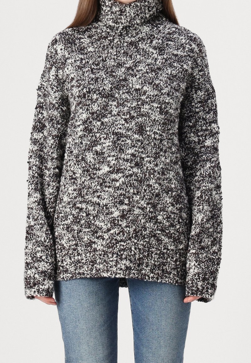 Gestrickter Rollkragenpullover in Schwarz und Weiß, mit einem strukturierten, gesprenkelten Muster und überschnittenen Schultern für eine lockere Passform.