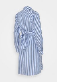 Niebieska i biała w paski sukienka koszulowa z kołnierzykiem, długimi rękawami oraz paskiem w talii, wykonana z lekkiego materiału.