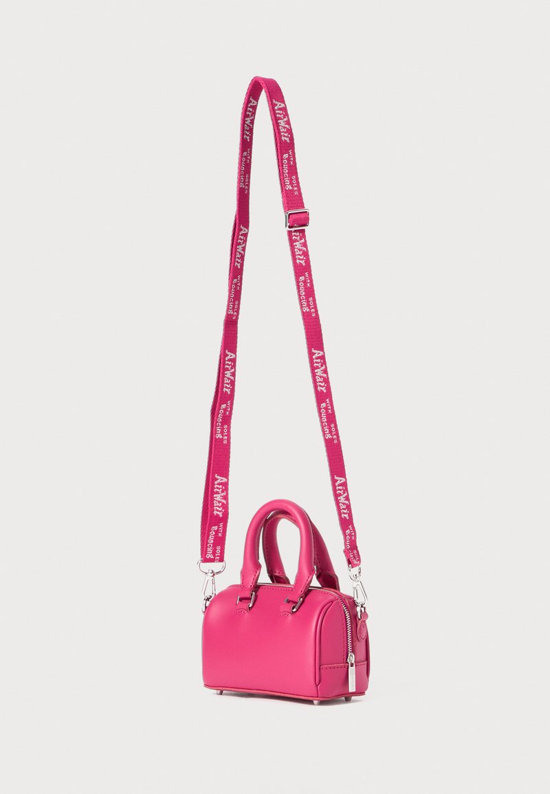 Sac à main en cuir rose avec doubles poignées, fermeture éclair et bandoulière détachable arborant un motif de logo répétitif. Design compact et arrondi.