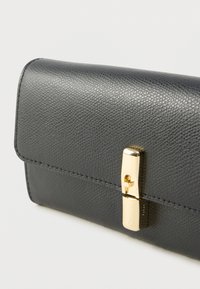 Pintakuvioitu musta nahkalompakko suorakaiteen muotoisena, jossa on kultavärinen lukitus ja siistit ompeleet reunoilla.