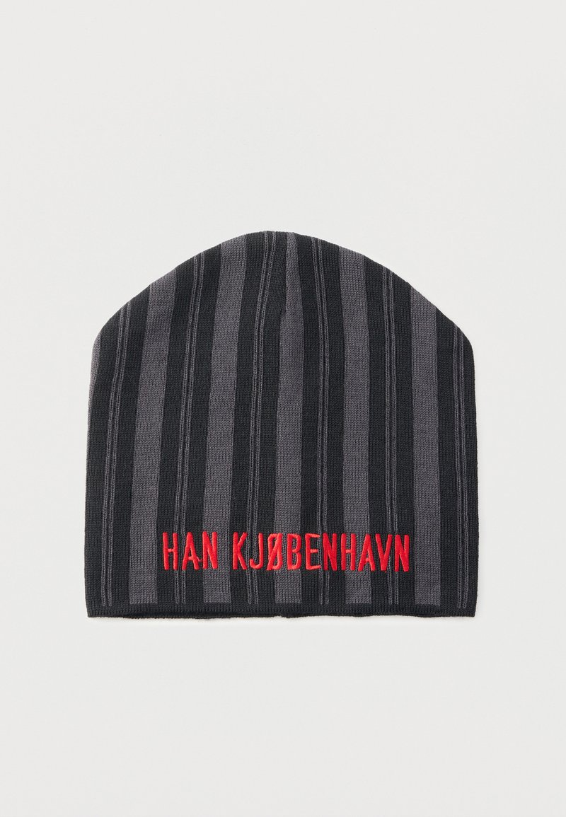 Kapa iz pletenega bombaža v črnih in sivih črtah, na sprednji strani z rdečim vezenim napisom "HAN KJØBENHAVN". Mehka tekstura, okrogla oblika.