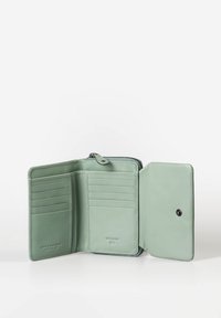 Groene leren portemonnee met een ritssluiting, interne kaartsleuven en een drukknoop. Gladde textuur, compact ontwerp en minimalistische uitstraling.