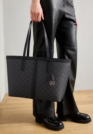 Must värvitoos, millel on mustri välispind, kahekordse ülaosa käepidemed ja kuldne logoaktsent. Valmistatud tekstuuriga materjalist, millel on struktureeritud kuju.