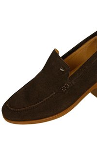 Scarpa slip-on in suede marrone con tomaia liscia, suola chiara e dettagli di cucitura decorativa sulla punta e sul lato.