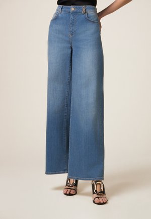 Lichtblauwe wijde jeans gemaakt van denim, met een hoge taille, twee voorzakken en een zilveren knoopaccent.