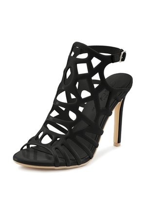Schwarze High-Heel-Sandalen mit offenem Design und geometrischen Ausschnitten, verstellbarem Knöchelriemen und einer glatten, strukturierten Sohle.