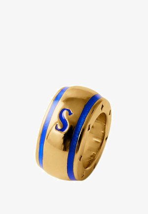 Anillo de metal dorado con un acabado brillante, que presenta una franja de esmalte azul y una letra "S" en relieve. Diseño redondeado con bordes suaves.