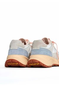 Zapatillas con una parte superior de ante suave en gris y azul, cordones rosas y una suela beige texturizada que presenta un prominente logotipo "HOFF" en el talón.