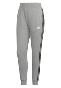 Grå jersey sweatpants med en bred elasticerad midja, smalnande ben, svarta sidostråk och vit Adidas-logga på framsidan.