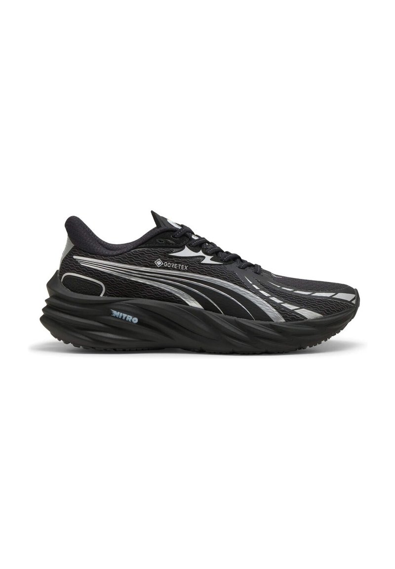 Scarpa da corsa nera realizzata in materiale GORE-TEX, con una tomaia testurizzata, suola curvata e dettagli riflettenti argentati.