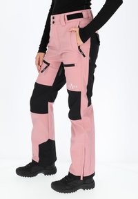 Pink and black waterproof pants with a smooth texture, zippered pockets, and reinforced sections on knees; features a branded logo.