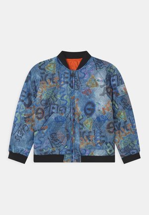Veste bomber bleue avec texte et symboles colorés style graffiti, col, poignets et ourlet noirs, fermeture éclair devant.