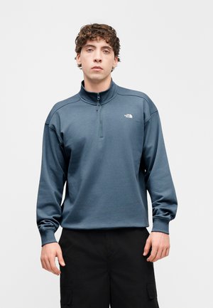 Fleece pullover in donkerblauw met een halve rits bij de kraag. Voorzien van een logo op de borst, lange mouwen en een losse pasvorm. Getextureerde stof.