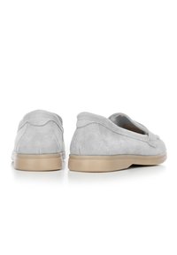 Šedé semišové slip-on boty s kulatou špičkou, nízkým béžovým podpatkem a bez viditelných zapínání. Měkká textura s jemnými švy.
