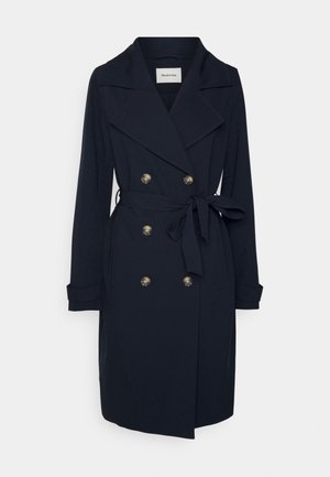 Ciemnoniebieski płaszcz trench z gładkiego materiału, z podwójnym zapięciem, złotymi guzikami i paskiem w talii do regulacji dopasowania.
