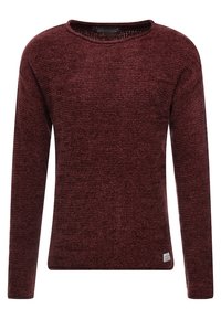 Czerwony sweter z dzianiny z długimi rękawami, okrągłym dekoltem, teksturowaną tkaniną oraz małą metką marki na dole po lewej stronie.