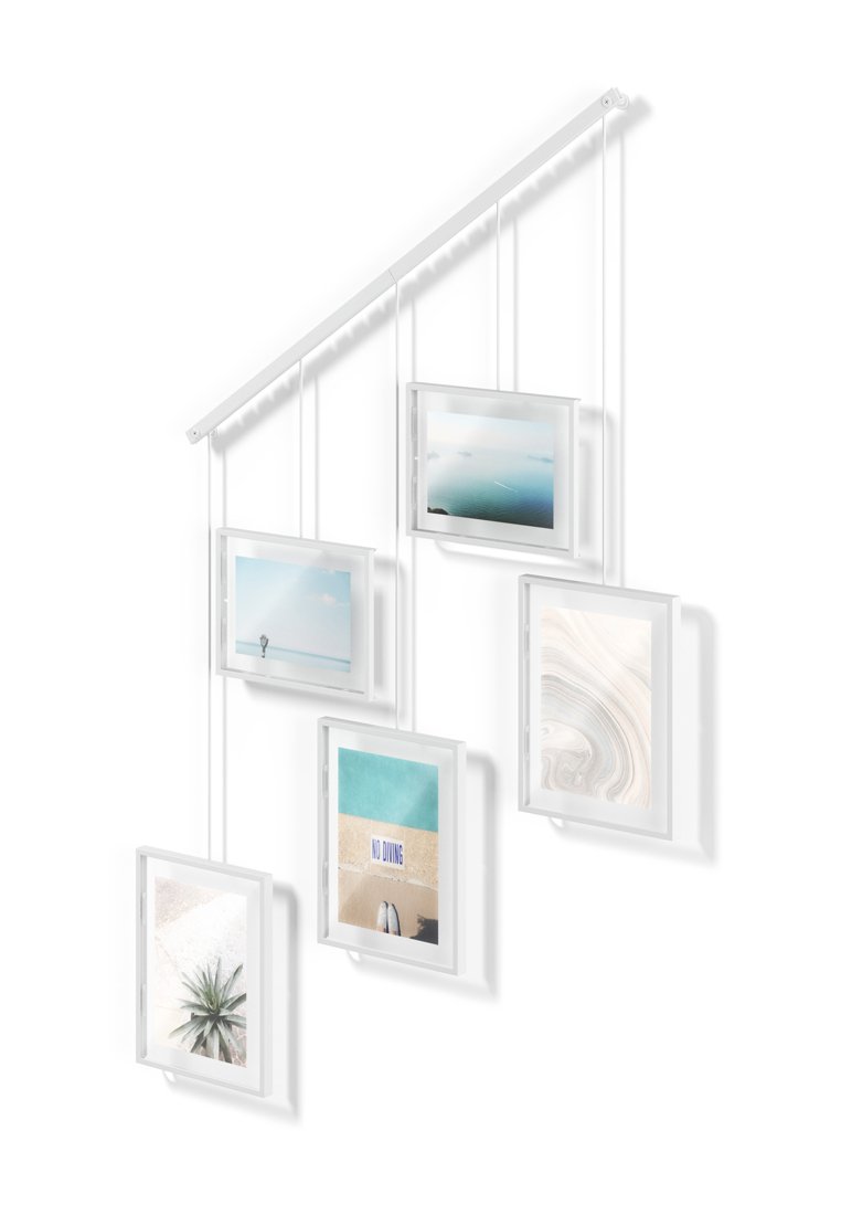 Fünf weiße Fotorahmen, die in unterschiedlichen Höhen von einem schrägen weißen Stab hängen und Bilder von Strand, Ozean und abstrakten Motiven zeigen.