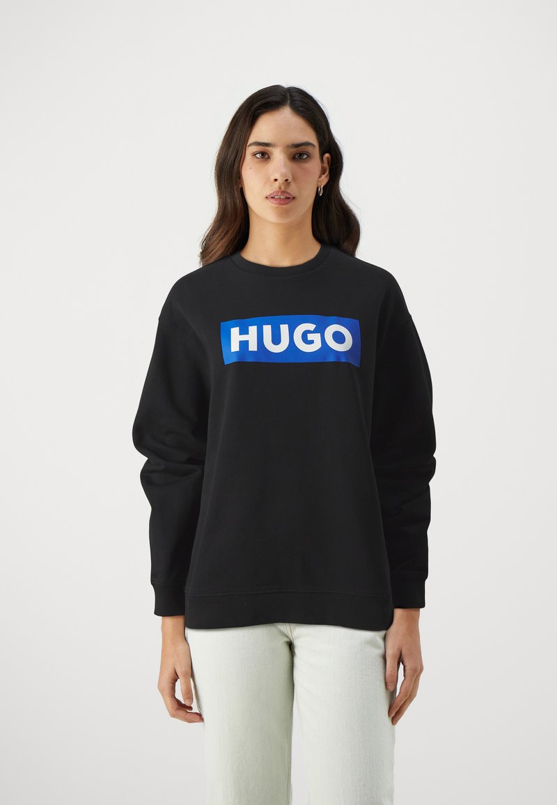 Čierny sveter s modro-bielym logom "HUGO" na prednej strane. Obsahuje okrúhly výstrih a dlhé rukávy. Mäkko, textúrované tkanivo.