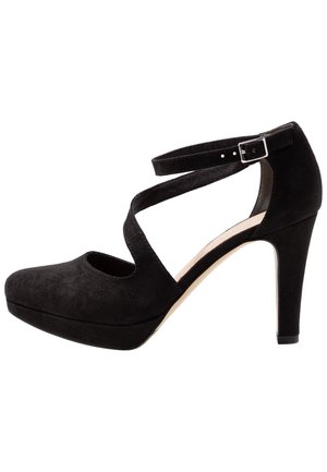Chaussure à talon haut en daim noir avec brides croisées à la cheville et boucle argentée, présentant un bout arrondi et une semelle compensée.