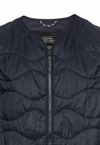Dunkelblauer Puffer-Jacke mit Wellenmuster-Nähten, runder Halsauschnitt und Frontreißverschluss mit strukturiertem Ziehband. Leichtes, glänzendes Material.