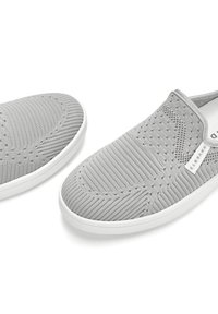 Gray slip-on shoes made of knit material with a textured surface, perforated pattern, and a white rubber outsole. Features a branded tag.